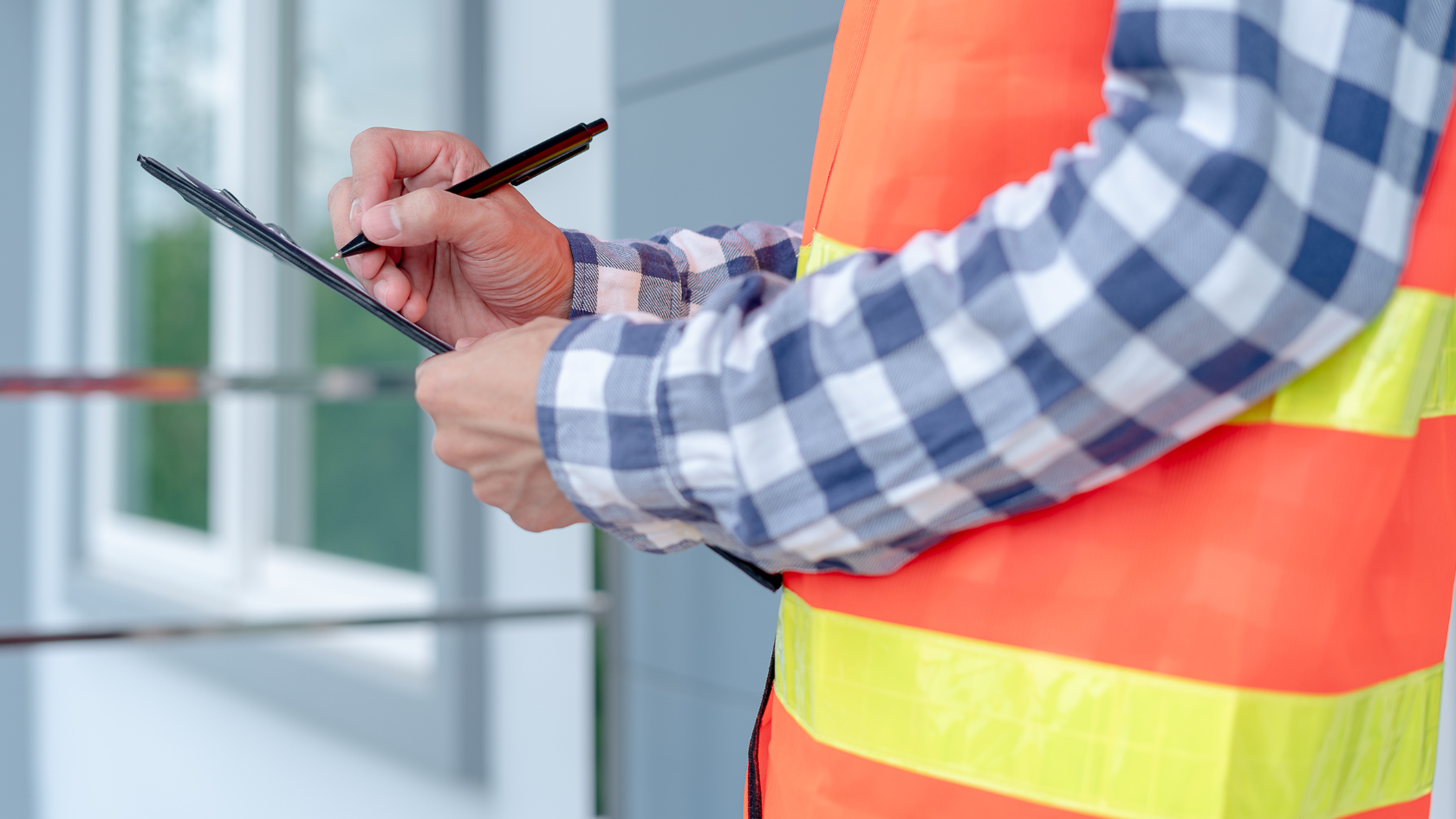 A construction worker writing on a clipboard