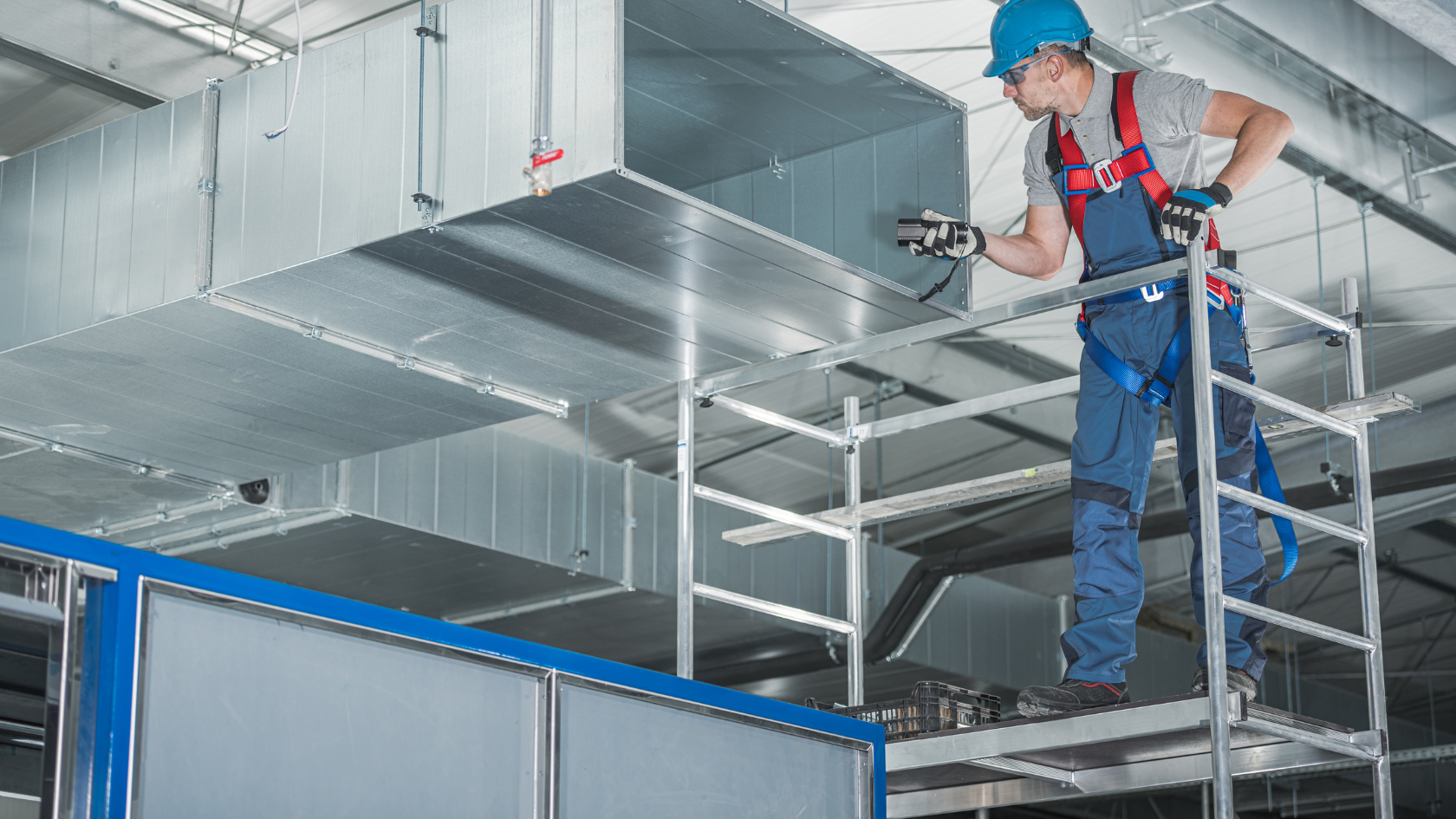 A man on a ladder working on a metal structure